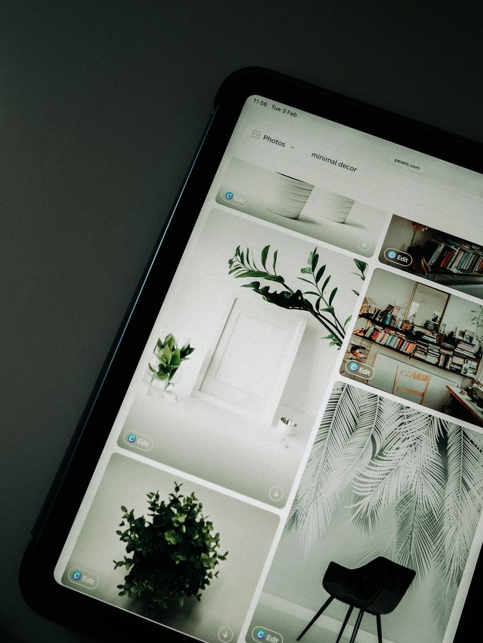 our-story Un écran de tablette affichant des images de décoration minimaliste, avec un accent sur la verdure et les lignes épurées.